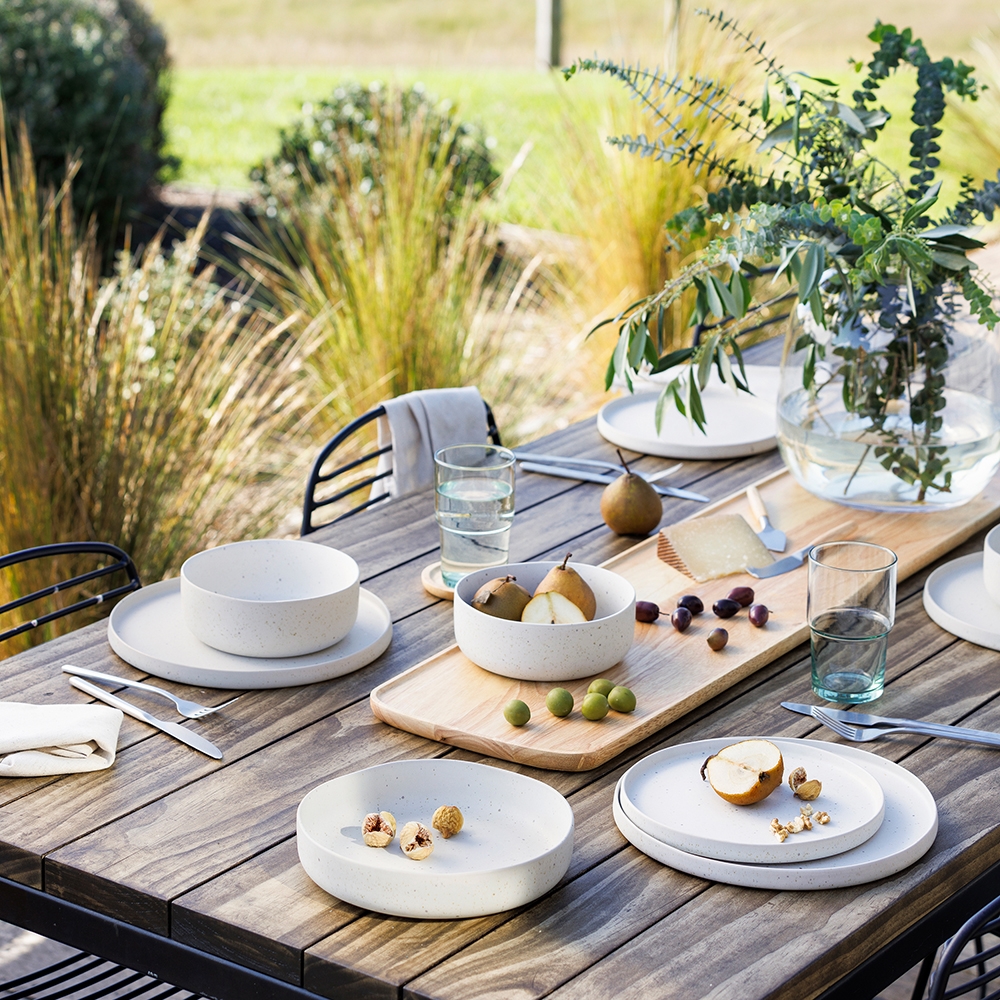 Ecology Domus recycled stoneware dinner setting on an outdoor wooden table next to Habitat recycled glasseware.